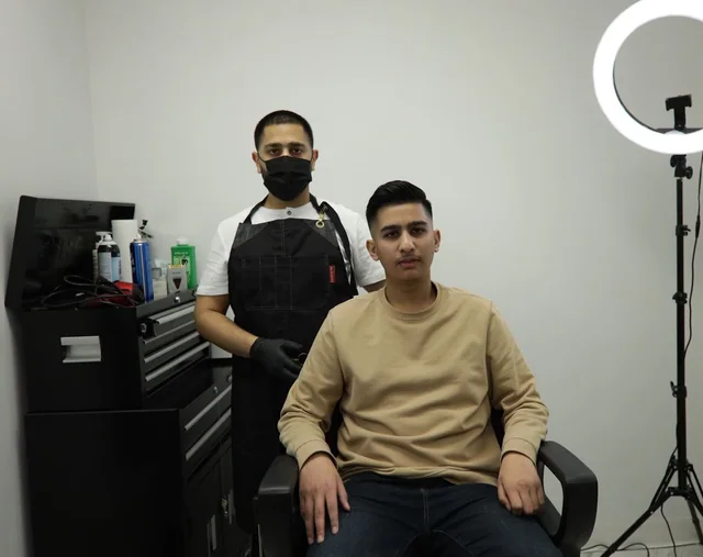 A barber with a client at Private Barbershop