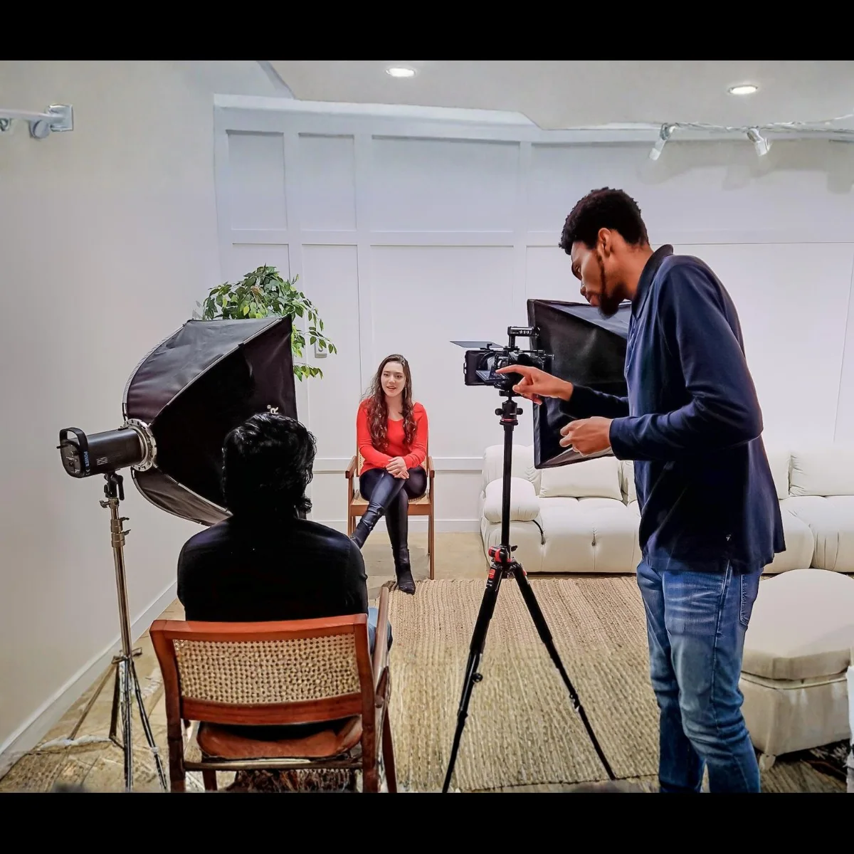 DK Visualsx crew filming a woman in red during an on-location interview